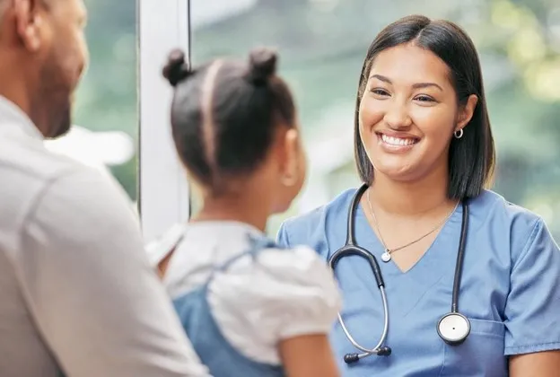 Smiling Nurse Interacting with a Family During a Medical Consultation